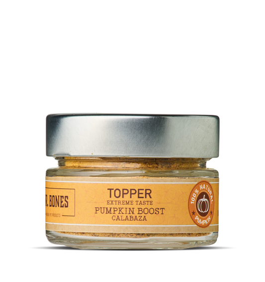 Glass jar of natural dehydrated pumpkin topper for dogs and cats with a wooden spoon, digestive health supplement.

