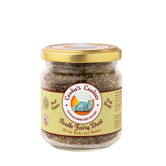 Close up of Tooth Fairy Magic Dust meal topper for dogs and cats, featuring natural seaweed, coconut, and parsley ingredients in a glass jar.