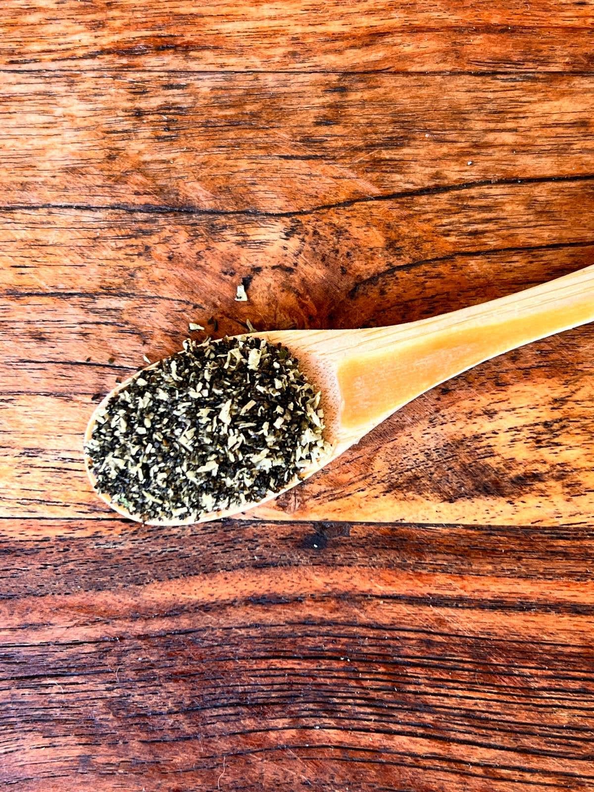 Close up of Tooth Fairy Magic Dust meal topper for dogs and cats, featuring natural seaweed, coconut, and parsley ingredients in a glass jar.