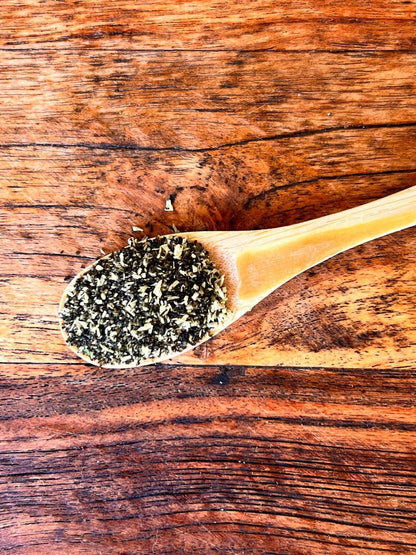 Close up of Tooth Fairy Magic Dust meal topper for dogs and cats, featuring natural seaweed, coconut, and parsley ingredients in a glass jar.